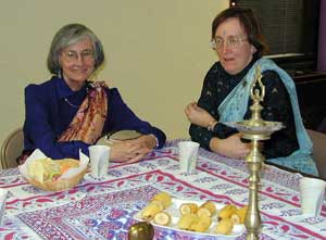 two women in saris at table